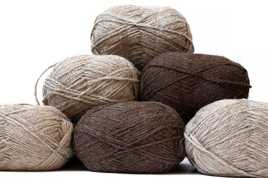 Wool yarns for knitting. Wool thread for knitting. Own hand. Knitting and needlework. Yarns for a scarf, sweater, and socks. Balls of yarn. Article about earning money at home with your hands. Article about knitting. Leisure for pensioners