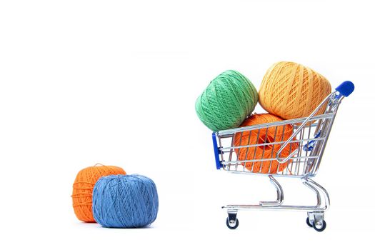 Trolley with yarn for knitting. Yarn for crocheting. Design of the embroidery section. Needlework. Hobbies and recreation. Colored threads on a white background. Isolated objects. Copy space