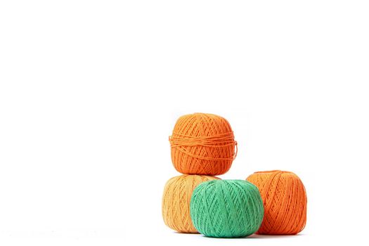 Colored balls of crochet thread on a white background . Copy space. The tangles are arranged in a column. Article about crocheting. Selection of threads for crocheting. Features of choosing a material for knitting. Made by the hands. Leisure for pensioners.