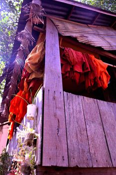 View of a hut and robes of Buddhist monks in the middle of the jungle