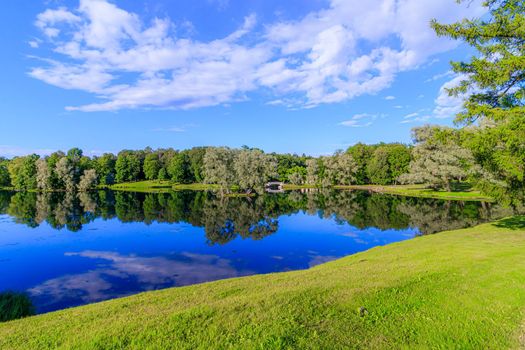 Summer evening in the Park with a lake. Summer landscape. nature of Russia. Well-maintained Park. Evening smoothness. The reflection in the water. Photo concept for printed products and puzzles