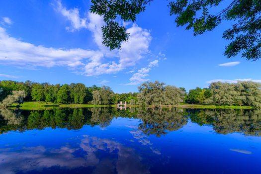 Summer evening in the Park with a lake. Summer landscape. nature of Russia. Well-maintained Park. Evening smoothness. The reflection in the water. Photo concept for printed products and puzzles