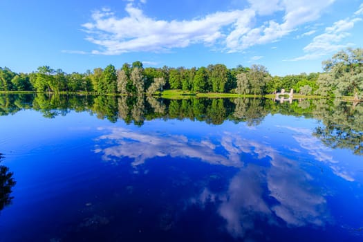 Summer evening in the Park with a lake. Summer landscape. nature of Russia. Well-maintained Park. Evening smoothness. The reflection in the water. Photo concept for printed products and puzzles