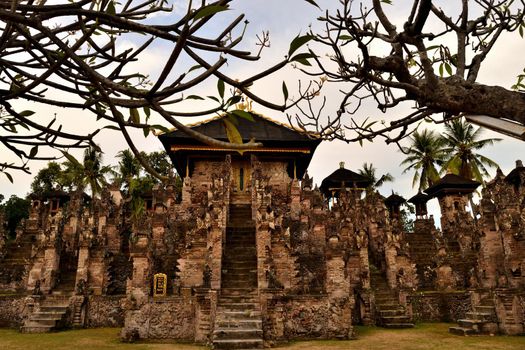 View of the Pura Beji temple behind a frangipani tree, Bali