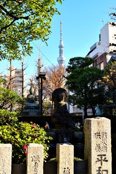 View of some Buddha statues in Asakusa district and in the distance the very high Sky Tree, Tokyo