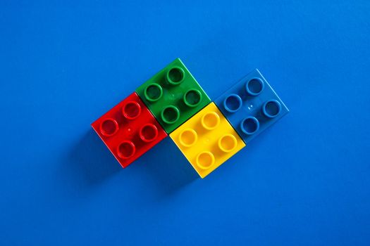 Plastic building blocks on blue background