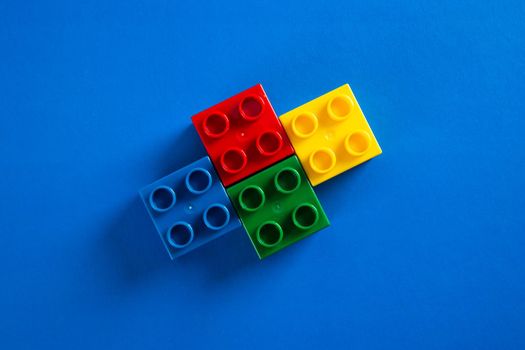 Plastic building blocks on blue background