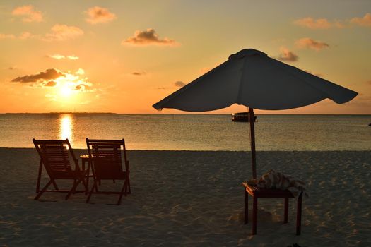 View of umbrella and sunbeds facing the Indian Ocean and the beautiful sunset, Asia.