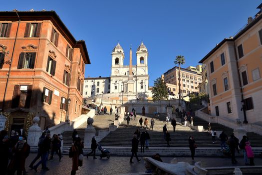 Rome, Italy - December 13th 2020: View of the Trinita dei Monti during the Covid-19 epidemic. Many people who wear protective face masks on their Christmas shopping stroll.