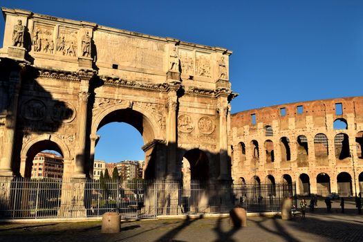 Rome, Italy - December 13th 2020: View of the Arch of Constantine and Coliseum with few tourists due to the Covid19 epidemic