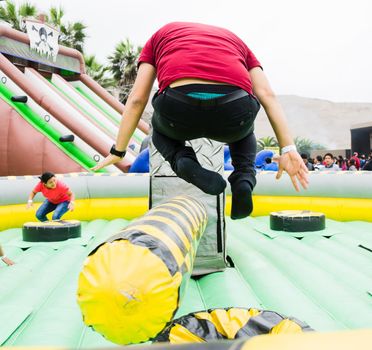 Young man jumping and dodging an obstacle in a game.