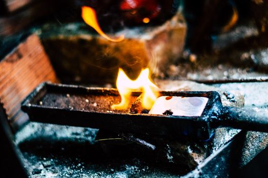 Craft jewellery making with professional tools. Macro shot. A handmade jewelry process, manufacture of jewellery. Melting silver