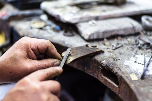 Hands of a jeweler making jewelry in his small workshop