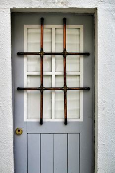 Gray wooden door with wrought iron fence in Lisbon, Portugal