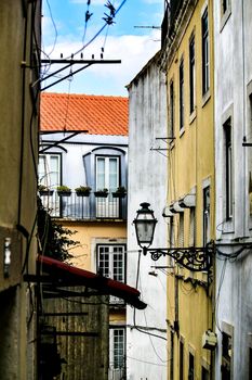 Old colorful and beautiful facades with vintage streetlight in Lisbon streets in Spring.