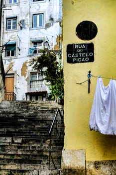 Narrow and colorful streets with majestic facades, windows and balconies of Lisbon city in Portugal in a cloudy day