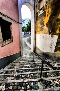 Narrow and colorful streets with majestic facades, windows and balconies of Lisbon city in Portugal in a cloudy day