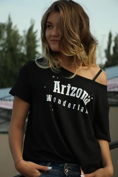 urban portrait of a flirty beautiful woman in black t-shirt and jeans at the stadium.