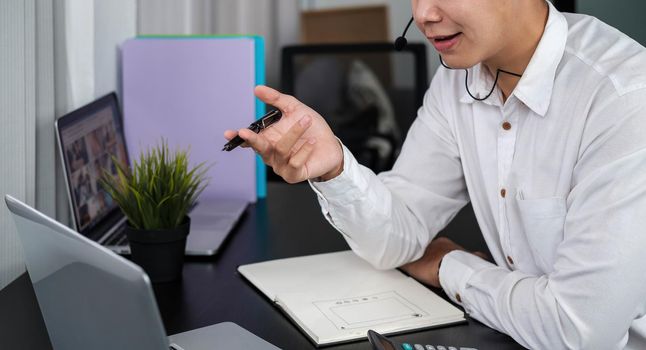 Asian man work call center support online working at home by laptop computer internet.