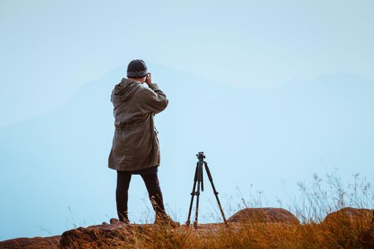 The cameraman was waiting to capture the sunrise in the morning.