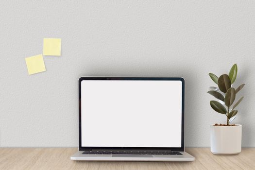 Cropped shot of minimal workspace with mock-up laptop, plant, decorations and copy space