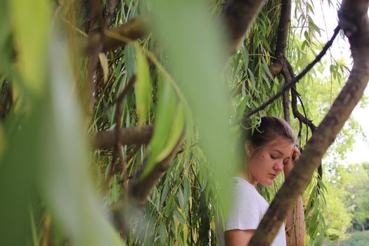 portrait of a flirty beautiful woman in white sport dress holding a tree branch in the tropical forest. Luxury resort.