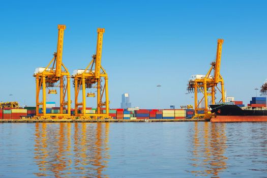 Container ship in export and import business and logistics. Shipping cargo to harbor by crane. Water transport International.