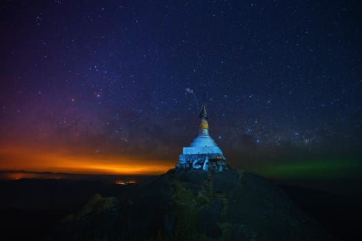 A pagoda on the top of the hill at night With a background full of stars