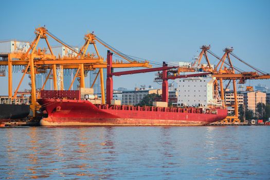 Container ship in export and import business and logistics. Shipping cargo to harbor by crane. Water transport International.
