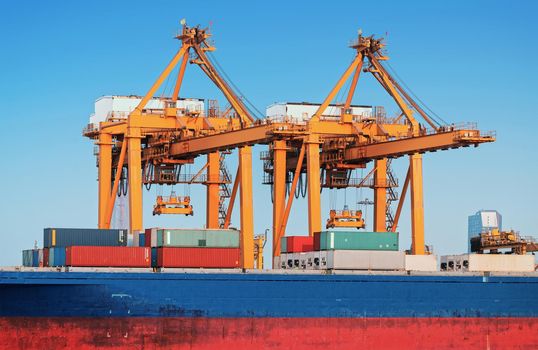 Container ship in export and import business and logistics. Shipping cargo to harbor by crane. Water transport International.