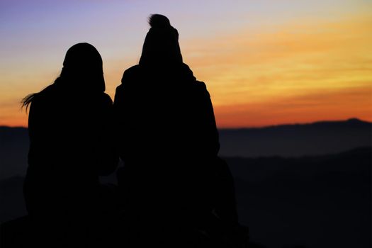 People sitting and watching the sunrise in the morning