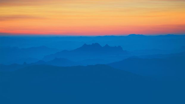 Mountain view in the morning. The background is orange sky.