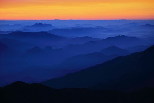 Mountain view in the morning. The background is orange sky.