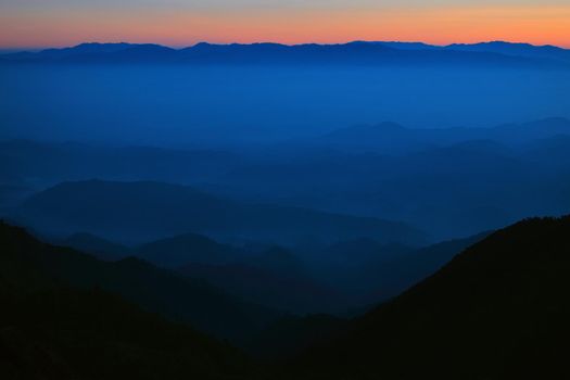 Mountain view in the morning. The background is orange sky.