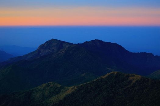 Mountain view in the morning. The background is orange sky.