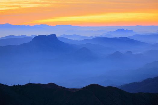 Mountain view in the morning. The background is orange sky.