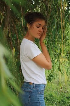 portrait of a flirty beautiful woman in white sport dress holding a tree branch in the tropical forest. Luxury resort.