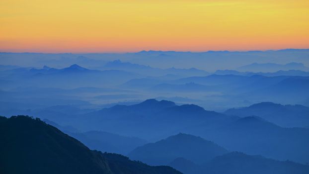 Mountain view in the morning. The background is orange sky.