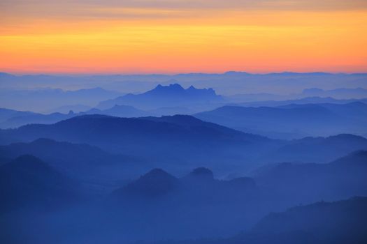Mountain view in the morning. The background is orange sky.