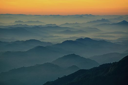 Mountain view in the morning. The background is orange sky.