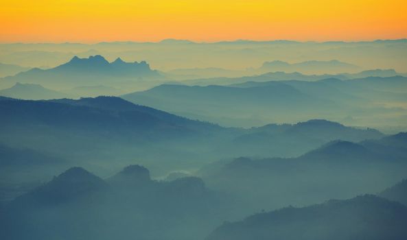 Mountain view in the morning. The background is orange sky.