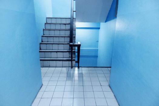 The stairs in the apartment have blue walls