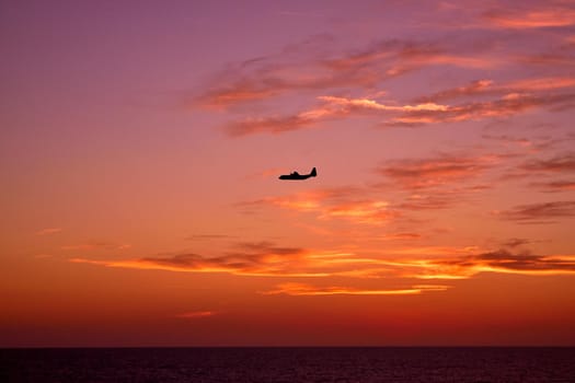 View of an airplane flying at sunset light. Wonderful