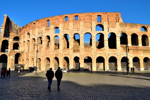 Rome, Italy - December 13th 2020: View of the Arch of Constantine and Coliseum with few tourists due to the Covid19 epidemic