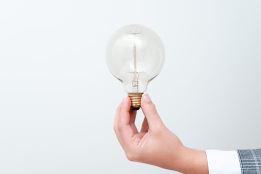 Woman Hand Holding Lamp Presenting Ideas For Project, Man Fists Showing Bulb And New Technologies, Held Lightbulb Exhibiting Another Opinion.