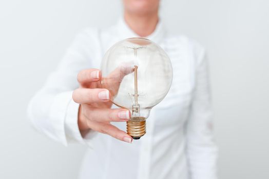 Lady Holding Lamp With Formal Outfit Presenting New Ideas For Project, Business Woman Showing Bulb With One Hand Exhibiting New Technologies, Lightbulb Presenting Another Openion.