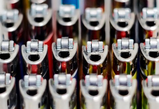 Close-up view of a group of many plastic lighters arranged in rows. Selective focus. Smoking and accessories. Concept of teamwork and unity