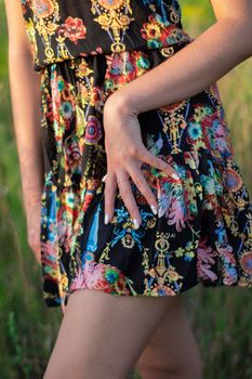 overlight bright portrait of a charming attractive blonde in flowery dress in the field.