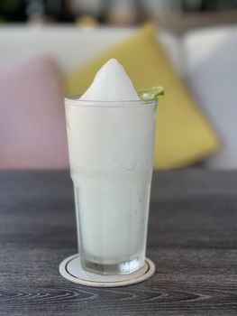 Lime smoothie in glass on grey table, stock photo