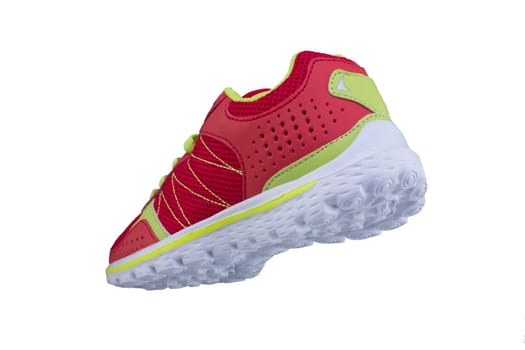 Red sneaker with green laces on a white sole. Sport shoes on white background